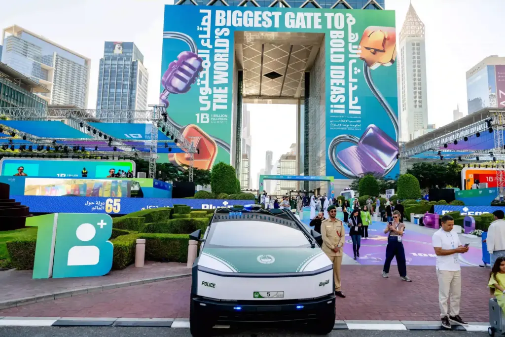 Entrance to the 1 Billion Followers Summit at the Dubai Frame, with large event branding, a Dubai Police electric patrol car and arriving crowds — powered by Glow Power Rental